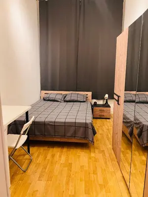 a bedroom with two beds and a table and a desk at Quarto da Nessa próximo a Louise in Brussels