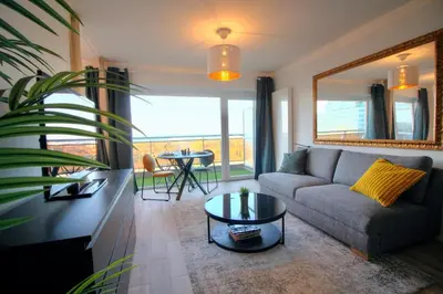 a living room with a couch and a table at Studio avec vue panoramique et parking gratuit in Brussels