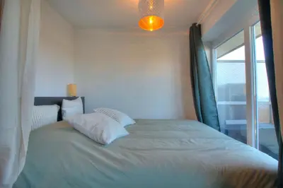 a bedroom with a large bed with a window at Studio avec vue panoramique et parking gratuit in Brussels