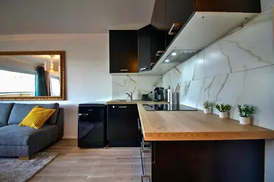 a kitchen with a counter and a couch in a room at Studio avec vue panoramique et parking gratuit in Brussels