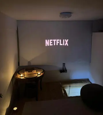 a small table in a room with a netflix sign at Magical double bedroom duplex in Brussels