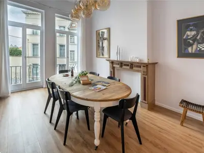 a dining room with a wooden table and chairs at Brussels Toison D'or residence in Brussels