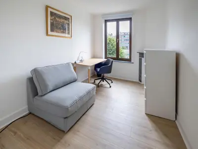 a living room with a chair and a desk at Brussels Toison D'or residence in Brussels