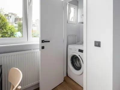a laundry room with a washing machine and a window at Brussels Toison D'or residence in Brussels