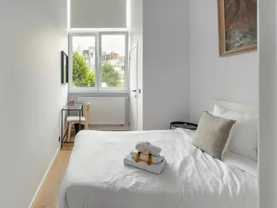 a white bed with a toy on top of it at Brussels Toison D'or residence in Brussels