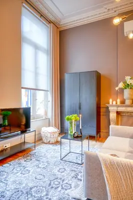 a living room with a couch and a tv at Historic Ghent Building - Ideal Studio Retreat in Ghent
