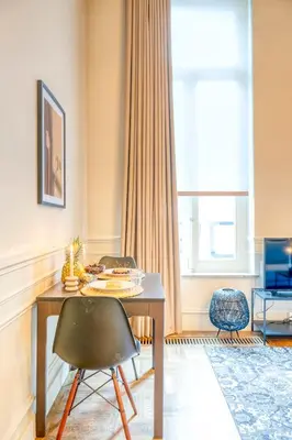 a dining room with a table and chairs and a window at Historic Ghent Building - Ideal Studio Retreat in Ghent