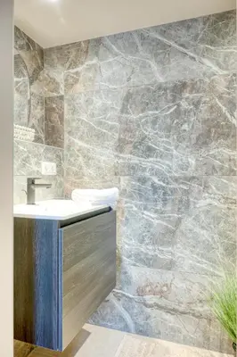 a bathroom with a sink and a stone wall at Historic Ghent Building - Ideal Studio Retreat in Ghent