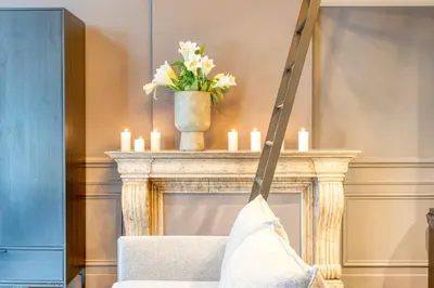 a robe hanging from a chair in front of a fireplace at Historic Ghent Building - Ideal Studio Retreat in Ghent
