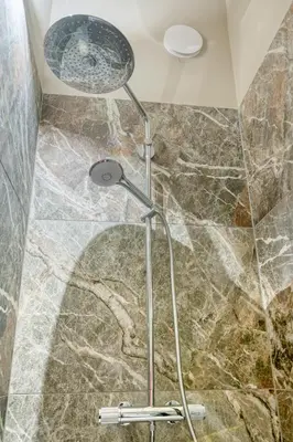 a shower in a bathroom with a stone floor at Historic Ghent Building - Ideal Studio Retreat in Ghent