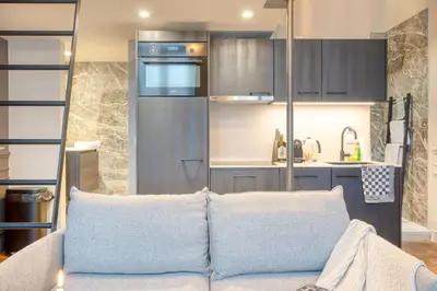 a living room with a couch and a kitchen at Historic Ghent Building - Ideal Studio Retreat in Ghent