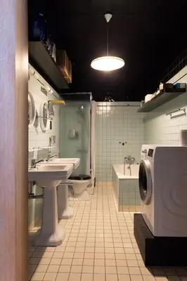 a bathroom with a sink and a washing machine in it at Art-deco woning Gent in Ghent