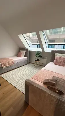 a attic bedroom with two beds and a window at Chez soi in Brussels