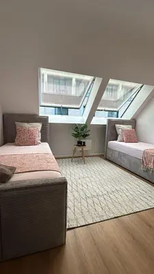 two beds in a room with two windows at Chez soi in Brussels