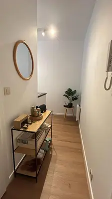 a hallway with a table and a mirror on the wall at Chez soi in Brussels