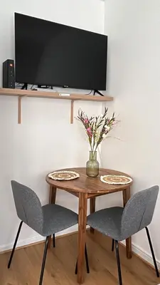 a table with two chairs and a television on a wall at Chez soi in Brussels