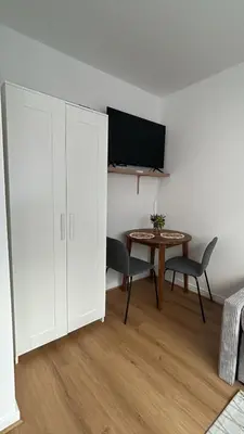 a living room with a table and a white cabinet at Chez soi in Brussels