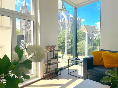 a living room with a blue couch and large windows at Apartment in the Heart of Ghent with Fantastic Views in Ghent
