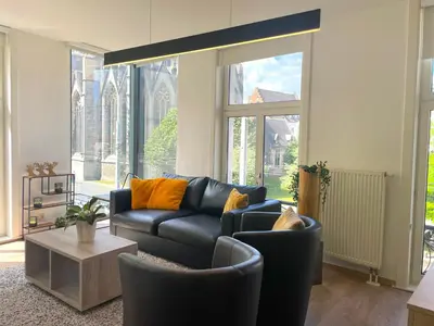 a living room with a black leather couch and chairs at Apartment in the Heart of Ghent with Fantastic Views in Ghent