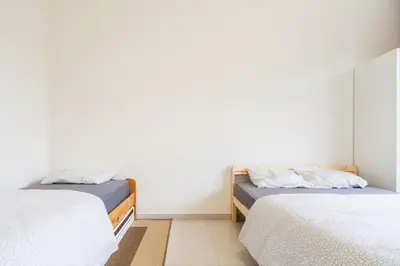 two beds in a room with white walls at Close to central station antwerp in Antwerp