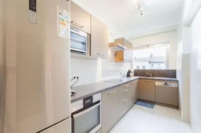 a kitchen with white cabinets and a sink at Close to central station antwerp in Antwerp