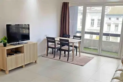 a living room with a table with chairs and a television at Close to central station antwerp in Antwerp