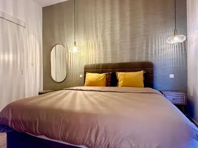 a bedroom with a large bed with two yellow pillows at Luxury Suits Royal by Rikas Hotels in Antwerp