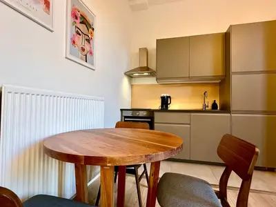 a kitchen with a wooden table and chairs in a room at Luxury Suits Royal by Rikas Hotels in Antwerp