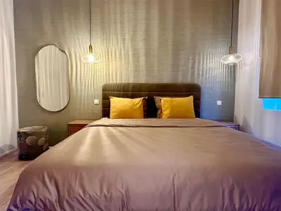 a bedroom with a large bed with yellow pillows at Luxury Suits Royal by Rikas Hotels in Antwerp