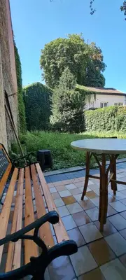 a wooden bench and a table on a patio at Smallfunnyworld Brussels in Brussels