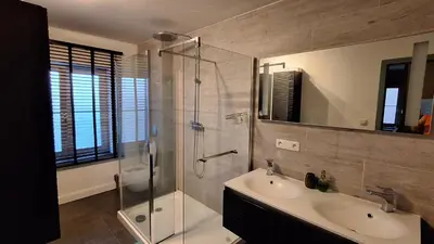 a bathroom with a glass shower and a sink at Holiday in de kempen in Turnhout