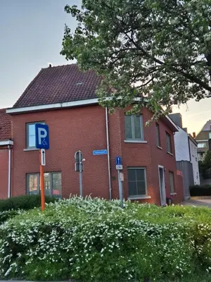 a red brick building with a parking sign in front of it at Holiday in de kempen in Turnhout