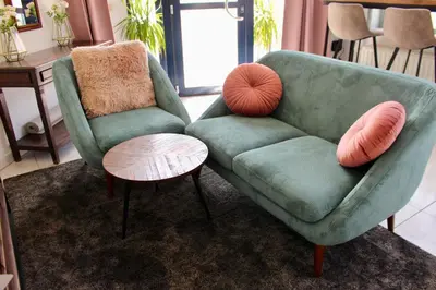 a living room with a green chair and a table at Cozy private suite in Ghent
