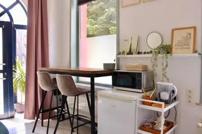 a kitchen with a table with chairs and a microwave at Cozy private suite in Ghent