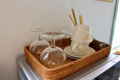 a basket with dishes and glasses on a counter at Cozy private suite in Ghent