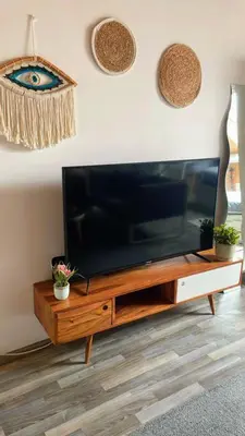 a flat screen tv sitting on top of a wooden entertainment center at Cosy place near Atomium with parking in Vilvoorde