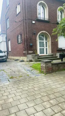 a brick building with a car parked in front of it at Cosy place near Atomium with parking in Vilvoorde
