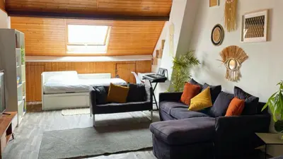a living room with a couch and a bed at Cosy place near Atomium with parking in Vilvoorde