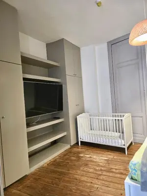 a room with a crib and a flat screen tv at Résidence Marianne 2 in Brussels