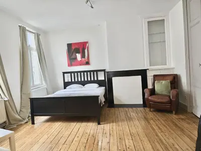 a bedroom with a bed and a chair at Résidence Marianne 2 in Brussels