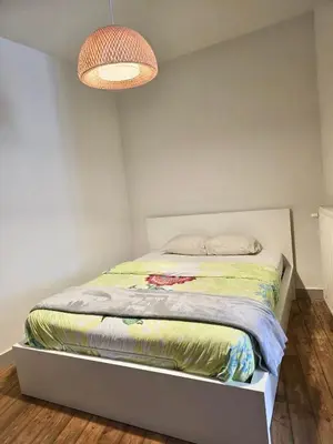 a small bedroom with a bed with a box under it at Résidence Marianne 2 in Brussels