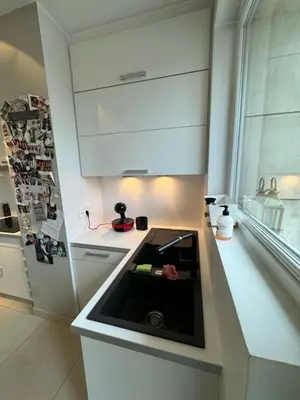 a kitchen with a sink and a refrigerator at Appartement Ixelles 2 chambres, 3 lits in Brussels
