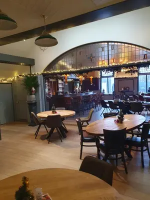 a restaurant with tables and chairs and a bar at De Baolse Herberg in Baarle-Hertog