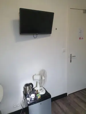 a room with a white wall with a flat screen tv at De Baolse Herberg in Baarle-Hertog