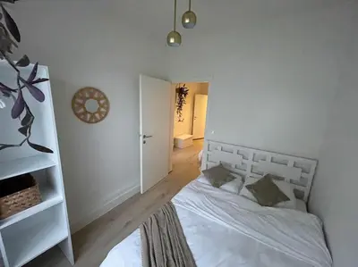 a bedroom with a bed and a white wall at E&L Appartement in Willebroek