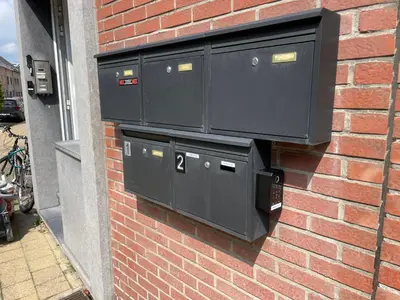 a brick wall with three black boxes on it at E&L Appartement in Willebroek