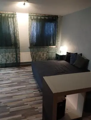 a bedroom with a bed and a table in it at Artistic appartment near downtown & railwaystation in Antwerp