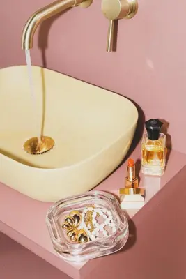 a bathroom counter with a sink and a bowl of cosmetics at The Mila Hotel in Brussels