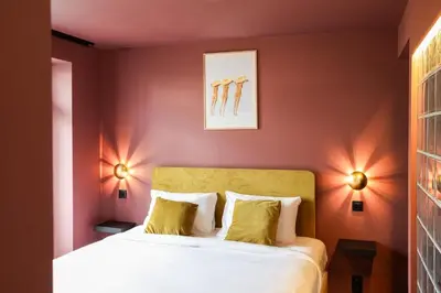 a bedroom with red walls and a bed with yellow pillows at The Mila Hotel in Brussels