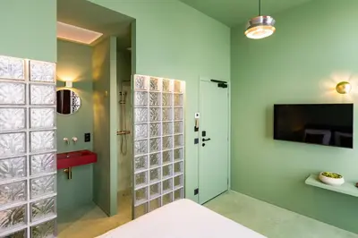 a bedroom with green walls and a sliding glass door at The Mila Hotel in Brussels